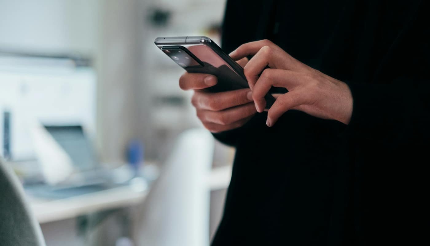 A person using a smartphone in a bright room