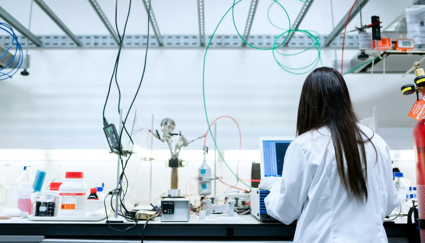 A researcher working at a laboratory bench with equipment and tubing